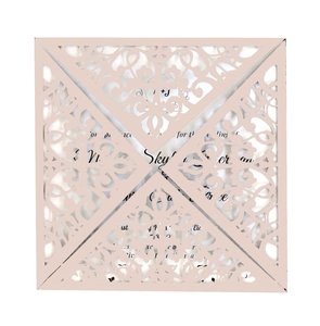 Detailed laser-cut pattern on light pink wedding invitation with ornate lace design