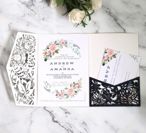 Elegant laser-cut floral wedding invitation set with glitter pocket on marble background