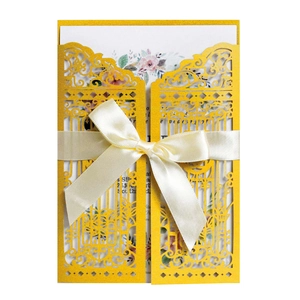 Gold laser-cut wedding invitation sleeve with satin bow and floral inner card detail