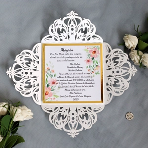 Detail of laser-cut hollow wedding invitation with gold border and floral patterns