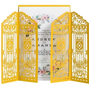 Macro detail of laser-cut gold wedding invitation cover with floral inner card