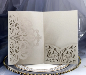 Detailed laser-cut Baroque floral pattern on elegant champagne gold wedding invitation