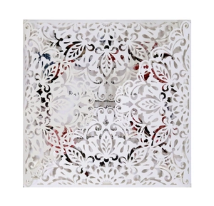 Intricate laser-cut white floral lace wedding invitation card with elegant paper sleeve