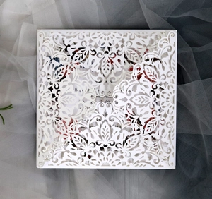 Detailed laser-cut floral pattern on a white square wedding invitation card