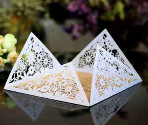 Macro detail of laser cut floral wedding invitation with intricate lace hollow patterns