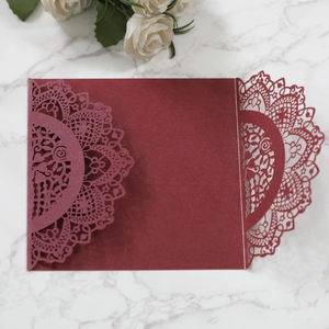 Macro shot of laser-cut burgundy wedding invitation cover with intricate mandala patterns
