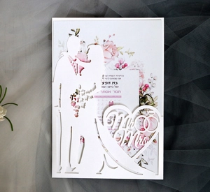 Detail of laser-cut wedding invitation featuring Mr & Mrs silhouette and floral pattern