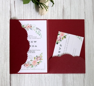 Detail of burgundy laser-cut lace wedding invitation with watercolor floral cards