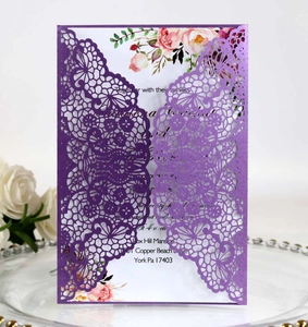 Intricate laser-cut lace detail on purple pearlescent wedding invitation with floral insert