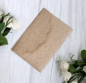 Macro view of gold glitter laser cut invitation card with textured shimmering finish