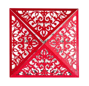 Red laser cut wedding invitation with intricate scroll patterns and white inner card