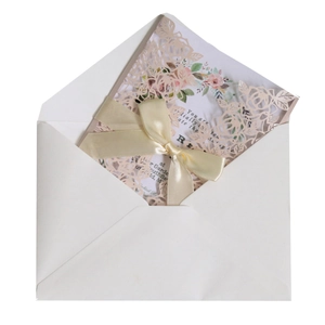 Pink laser-cut rose wedding invitation with a yellow silk ribbon and white envelope
