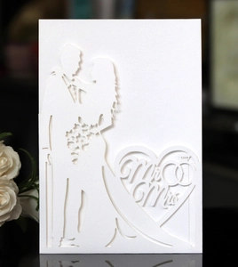 Detail of laser-cut wedding invitation featuring Mr & Mrs silhouette and heart patterns