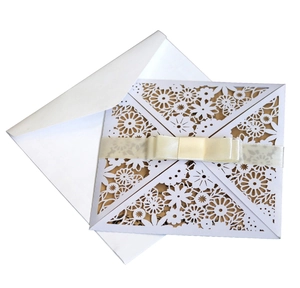 Detailed laser cut floral invitation card with an elegant cream ribbon and bow