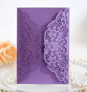Close-up of laser-cut lace design on dark purple pearlescent wedding invitation card