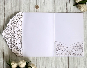 Elegant white laser-cut wedding invitation pocket with intricate lace floral patterns