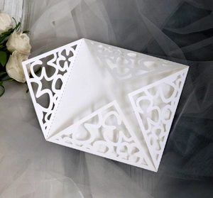 Detail of white laser cut wedding invitation with lace floral pattern and butterfly design