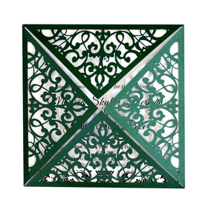 Detail of laser-cut dark green wedding invitation with vintage hollow lace pattern