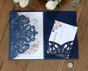 Detailed laser-cut navy blue wedding invitation set with elegant floral patterns