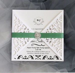 Elegante lasergeschnittene Hochzeitseinladung mit weißem Muster, grünem Band und Strass