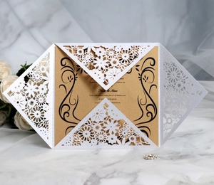 Detail of laser-cut floral wedding invitation with white lace shell and golden pearlescent insert