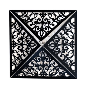 Elegant laser-cut black wedding invitation card with intricate floral hollow patterns