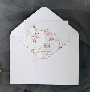 Macro detail of laser-cut wedding invitation featuring a couple silhouette and floral print
