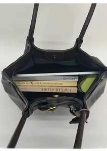 Spacious interior of dark brown vintage tote showing tablet and books with magnetic buckle