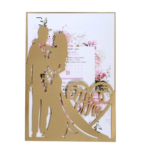 Detailed laser-cut wedding invitation featuring a golden silhouette and floral insert card