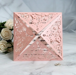 Close-up of laser-cut pink pearlescent paper wedding invitation with floral lace detail