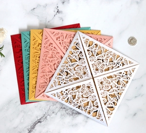 Macro detail of laser cut butterfly wedding invitations in five vibrant colors