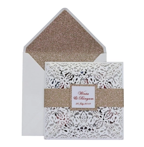 Detail of laser-cut wedding invitation with champagne gold glitter lining and floral patterns