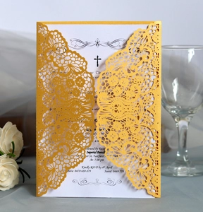 Detail of laser-cut gold wedding invitation with elegant floral hollow pattern and white insert