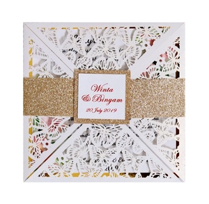 Laser-cut white butterfly wedding invitation with a glitter gold belly band and tag