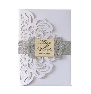 Detail of laser-cut lace wedding invitation with silver glitter band and custom name card