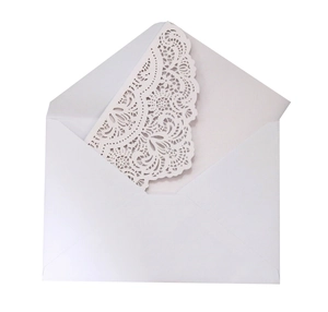 Elegant white laser-cut wedding invitation set with intricate lace pattern and envelope