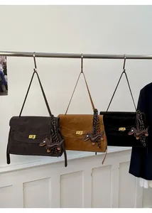 Three suede handbags in dark coffee, caramel, and black with dachshund charms