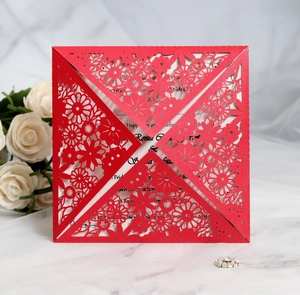 Macro shot of red laser-cut floral invitation cover with delicate lace hollow patterns
