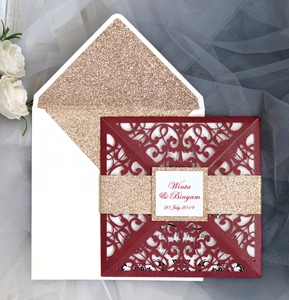 Burgundy laser-cut wedding invitation with gold glitter band and floral envelope liner