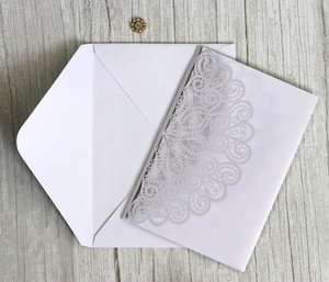 Macro detail of laser-cut mandala white wedding invitation with luxury envelope