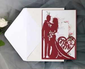 Detail of laser cut burgundy wedding invitation with elegant Mr & Mrs silhouette design