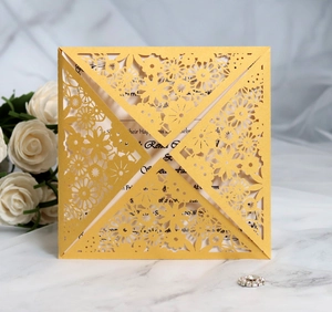 Close-up of golden laser-cut floral wedding invitation with pearlescent paper finish