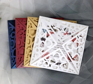 Detail of laser-cut floral wedding invitations in navy, burgundy, gold and white