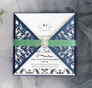 Details der lasergeschnittenen Hochzeitseinladung mit Schleife und Strass-Schnalle