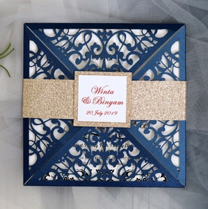 Detail of navy blue laser cut wedding invitation with glitter gold band and custom card