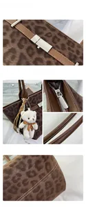 Close-up of leopard print suede tote with silver zipper and plush bear charm detail