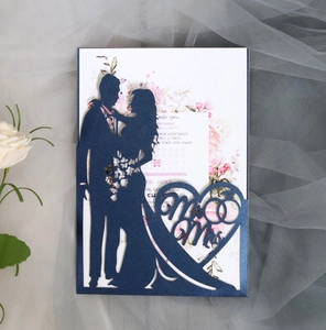 Macro view of navy blue laser cut wedding invitation with Mr & Mrs silhouette and floral insert