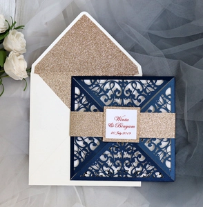 Detailed laser-cut wedding invitation set with navy sleeve and gold glitter envelope lining