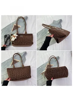 Detail view of large leopard print tote bag with metal twist lock and bear charm