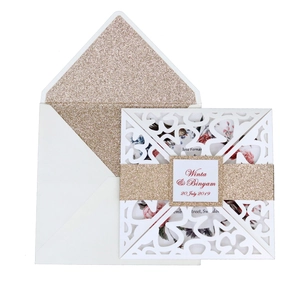 Detail of laser-cut lace invitation cover with rose gold glitter belly band and envelope